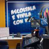 Alle spalle una porzione della parete � stata interamente colorata di blu, riproducendo un motivo a mattoncini su cui spicca in bianco il motto �Ascoltala e vivila con noi�